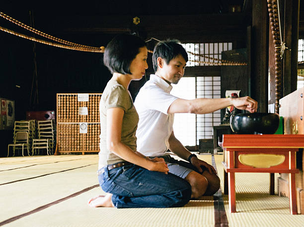 Japanese couple praying in a buddhist temple in Kyoto, Japan