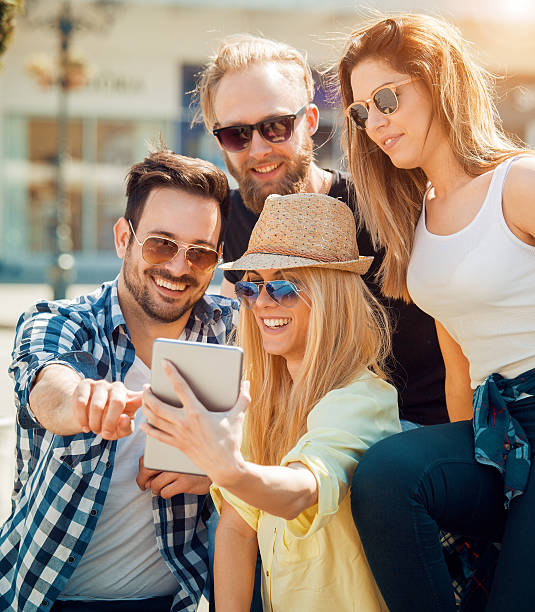 istock Group of four happy friends taking selfie 564602100