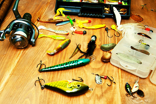 istock Fishing baits and rod isolated on wooden background 564602184