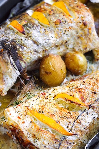 istock Baked haddock with lemon slices and small potatoes 564602630