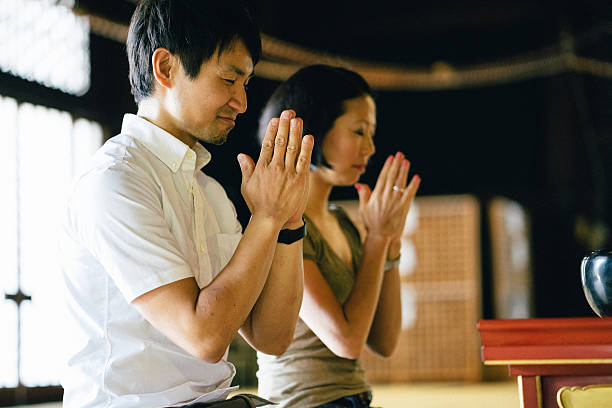 istock Japanese couple praying in a buddhist temple 564602664