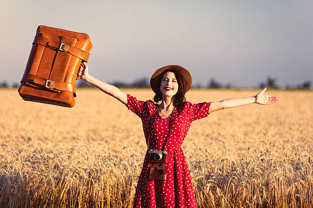 istock young woman with suitcase and camera 564604772