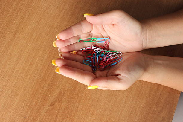 istock Full hands of colorful paper clips 564606350