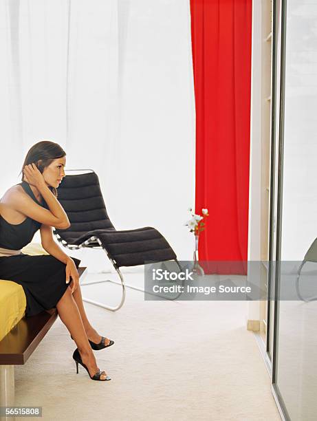 Stylish Woman Sitting On A Bed Stock Photo - Download Image Now - Adult, Adults Only, Bed - Furniture