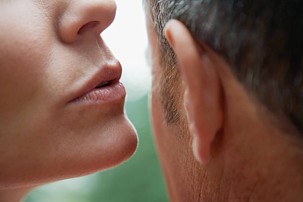 susurrar hombre mujer en la oreja - human ear fotografías e imágenes de stock