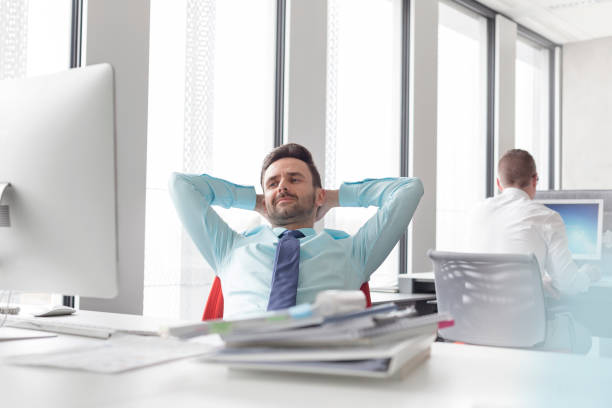 istock Relaxed businessman leaning with hands behind head at computer in office 567166263
