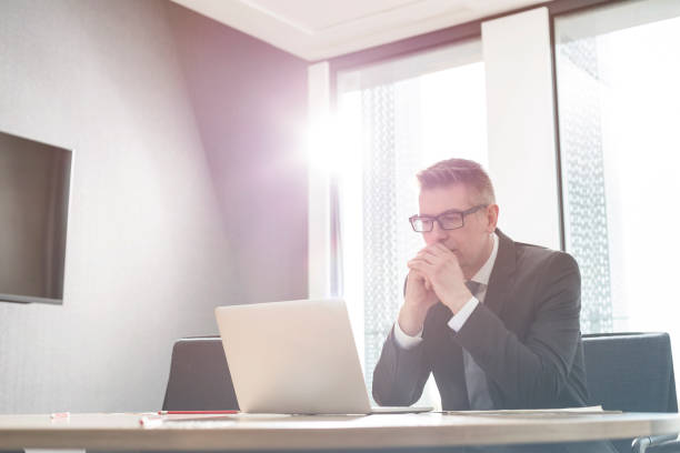 istock Focused businessman working at laptop in sunny office 567166323