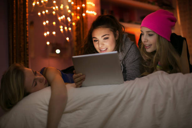 istock Teenage girls using digital tablet on bed 568518223