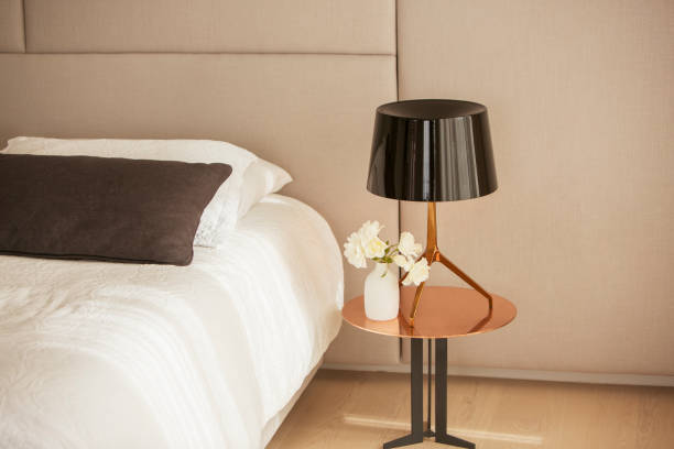 istock Lamp and rose bouquet on bedside table 568518451