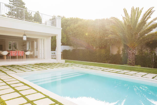 istock Luxury swimming pool surrounded by paver stones 568518547