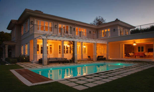 istock Illuminated luxury house with swimming pool at night 568518559