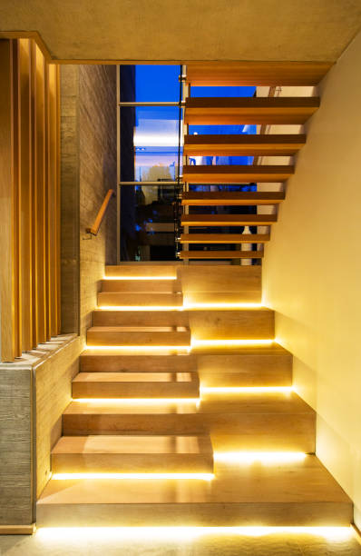 istock Illuminated modern wood stairs in luxury house 568518651