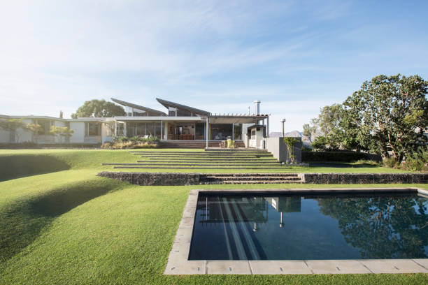 istock Modern swimming pool, yard and house 568518737