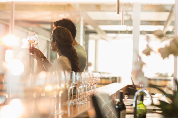 istock Couple wine tasting in sunny winery tasting room 568518855