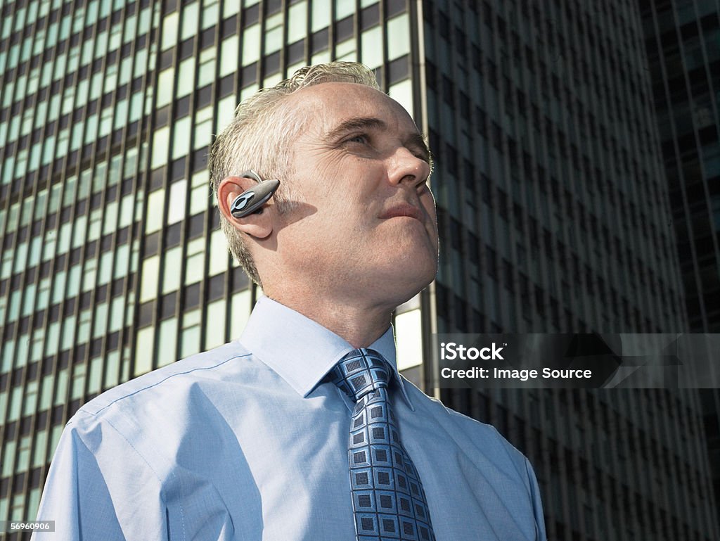 Empresário vestindo um recipiente de auscultadores com microfone - Royalty-free A usar um telefone Foto de stock