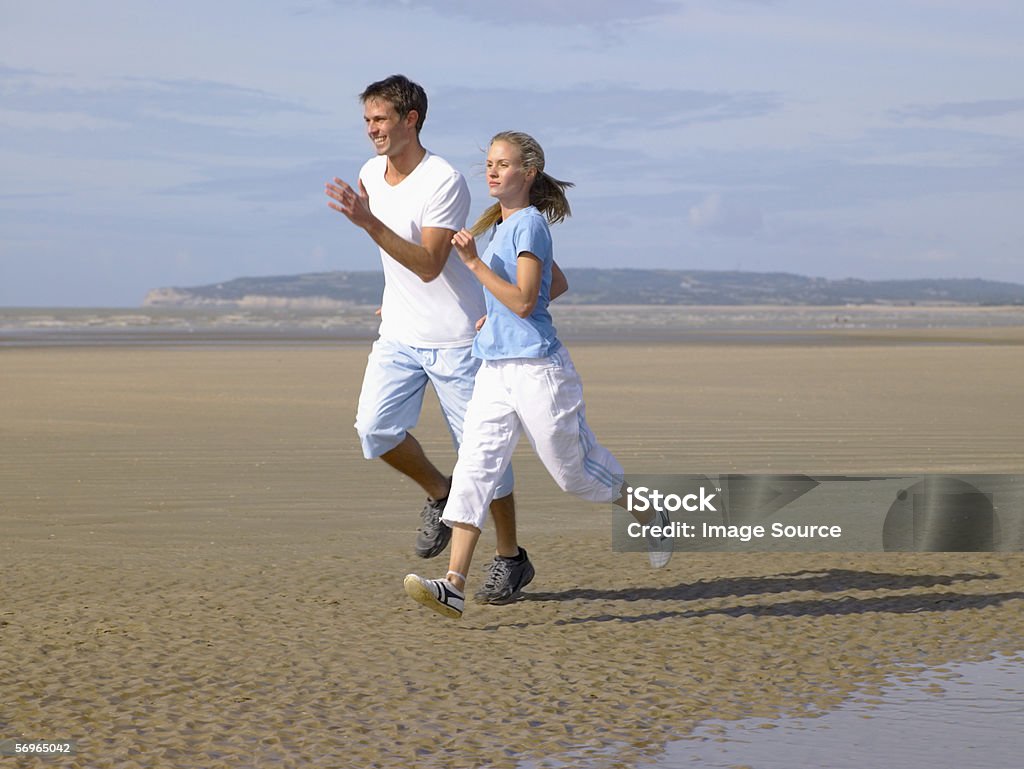 Couple running on the beach  Active Lifestyle Stock Photo