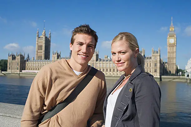 Photo of Couple by River Thames near Houses of Parliament