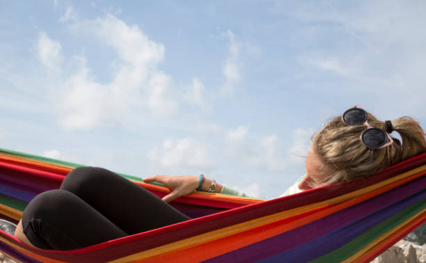 istock Young woman relaxes in hammock, sleeping 570263031