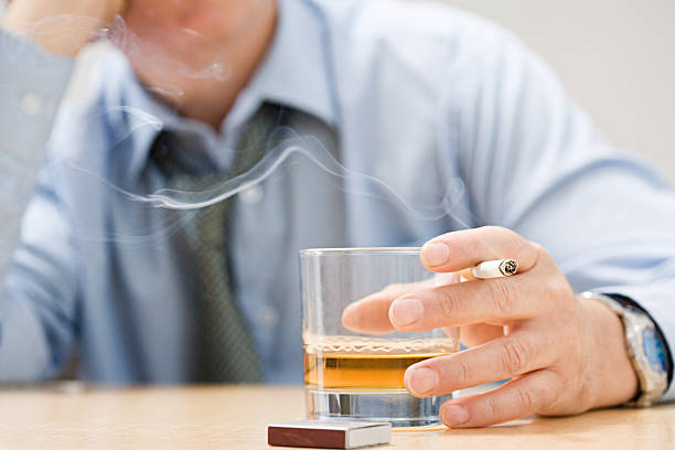 mann trinkt whisky und nichtraucher - ungesund leben stock-fotos und bilder