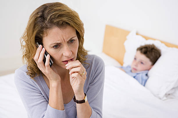 mother on telephone with sick son - offspring child lying on back parent imagens e fotografias de stock