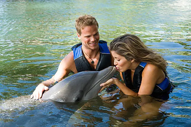 Photo of Woman kissing dolphin