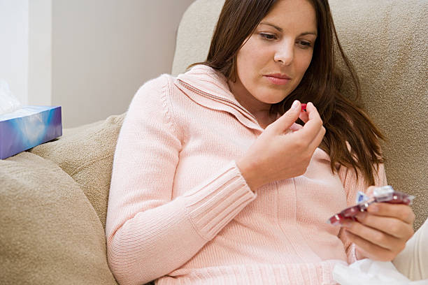 Woman taking a cough lozenge  cough lozenge stock pictures, royalty-free photos & images