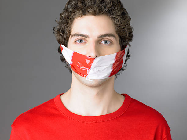 Man with police tape over his mouth  speak no evil stock pictures, royalty-free photos & images