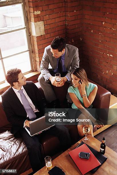 Colleagues In A Bar - Fotografias de stock e mais imagens de Bar - Local de entretenimento - Bar - Local de entretenimento, Computador Portátil, Escritório