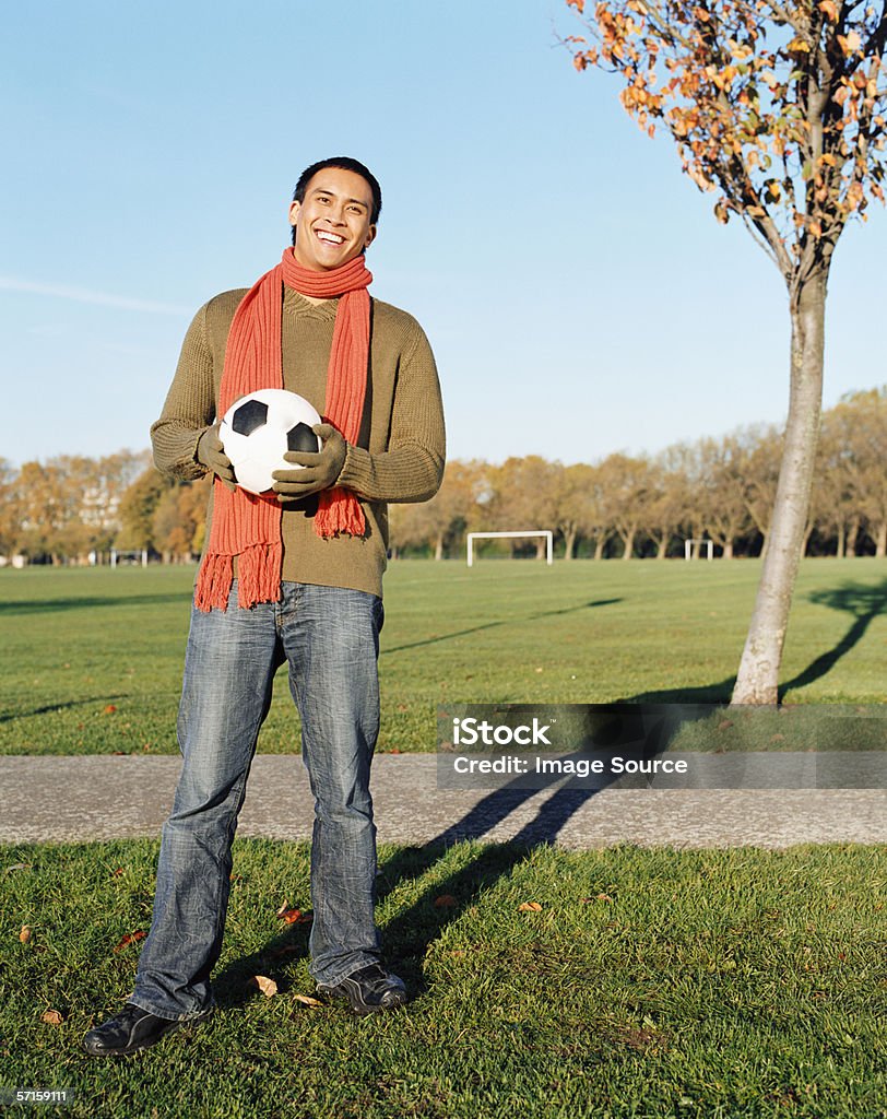 Man holding a football in park  Adult Stock Photo