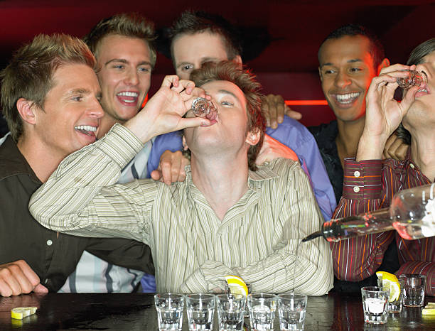 hombre bebiendo tomas en un bar - exceso fotos fotografías e imágenes de stock