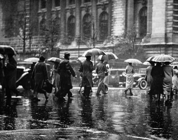 Pedestrian passing street, rainy weather, New York, USA (B&W)  puddle photos stock pictures, royalty-free photos & images