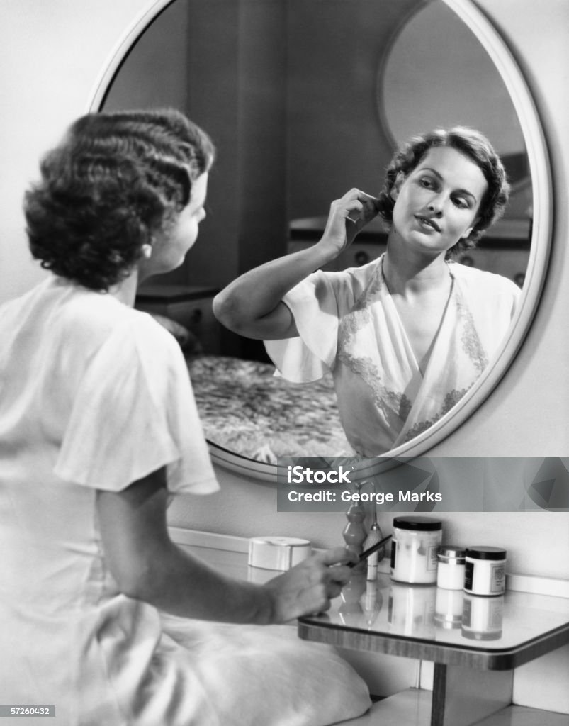 Donna facendo i capelli Davanti allo specchietto (B & W - Foto stock royalty-free di Donne