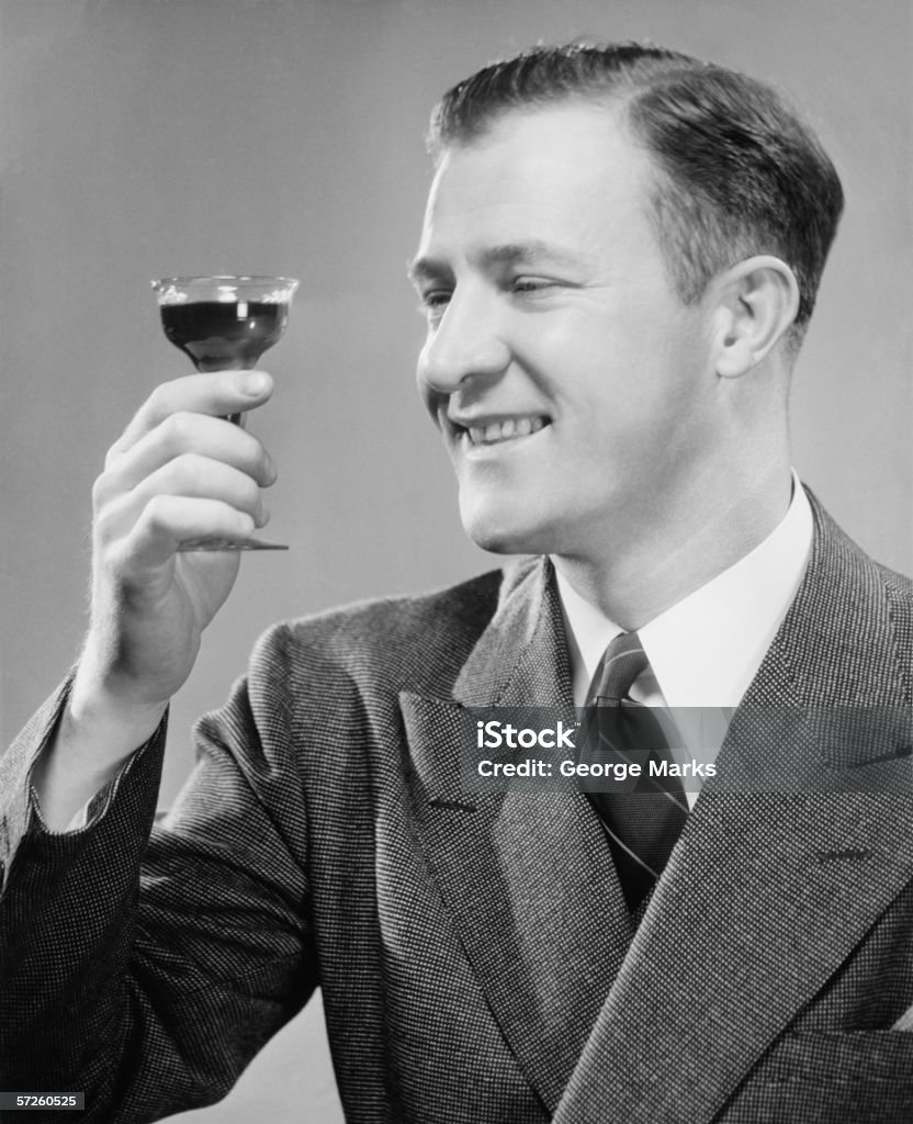 Sonriente hombre que agarra corto vidrio con una bebida, (B & P), primer plano - Foto de stock de Beber libre de derechos