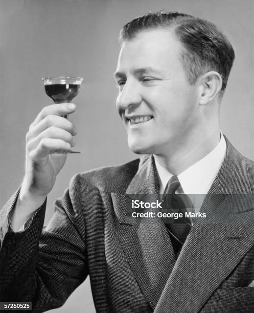 Sonriente Hombre Que Agarra Corto Vidrio Con Una Bebida Primer Plano Foto de stock y más banco de imágenes de Beber