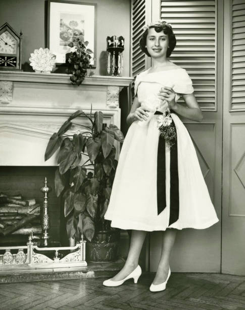 donna in posa in abito elegante camino, (b & w - camera retro revival old fashioned holding foto e immagini stock