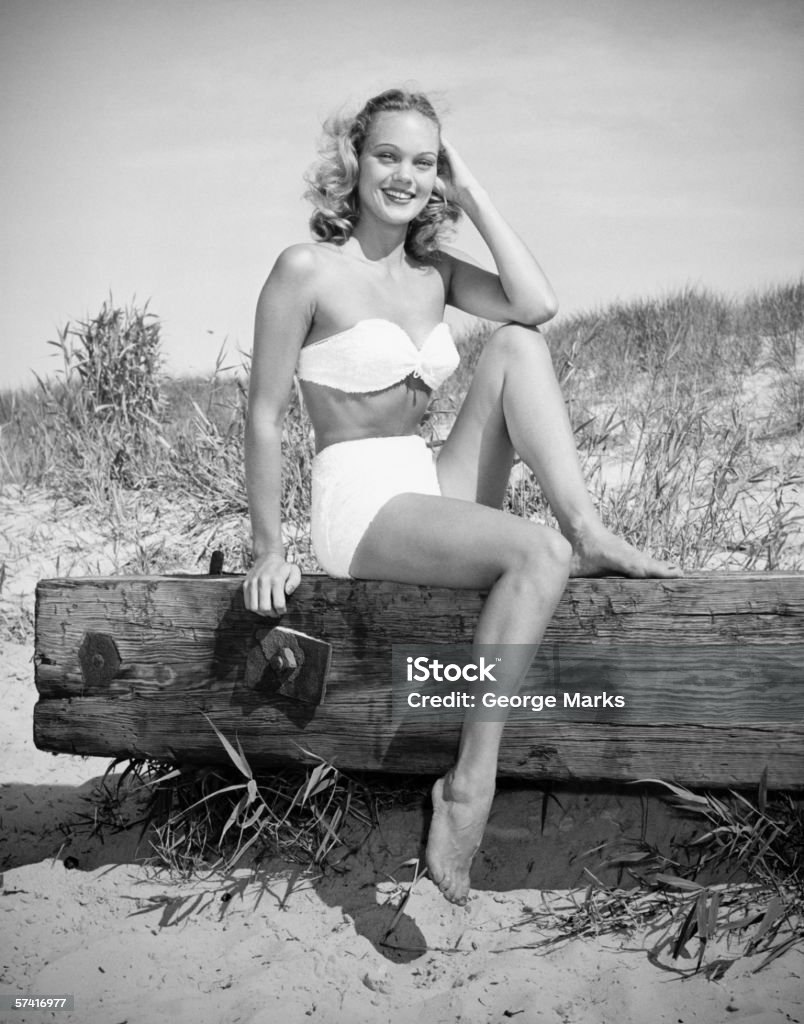 Frau mit bikini sitzt auf Login beach, (B & W), (Abbildung - Lizenzfrei Altertümlich Stock-Foto