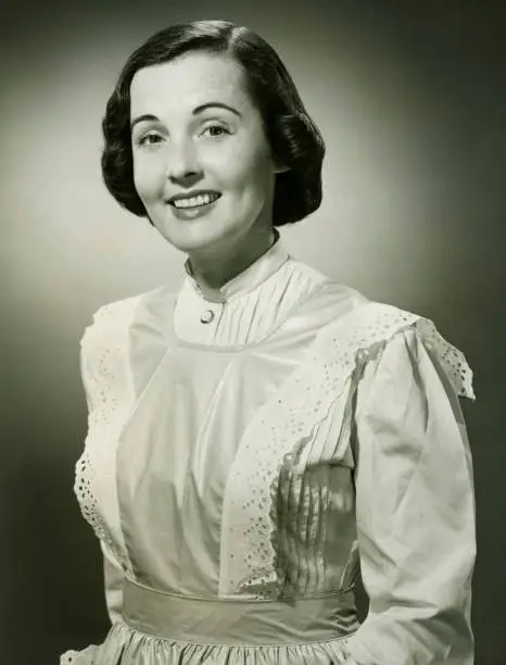 Photo of Woman in white apron posing in studio, (B&W), (Portrait)