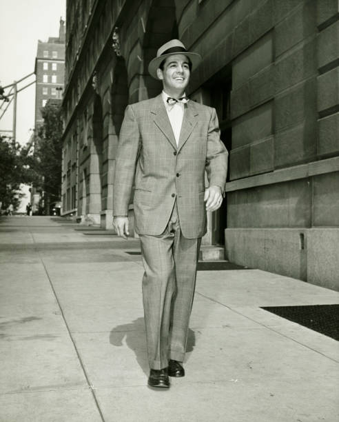 エレガントな man walking on サイドウォーク（b &w - men fedora hat 1940s style ストックフォトと画像