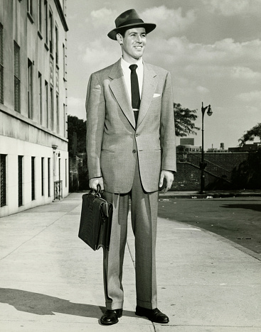 Hombre en traje completo de pie en la acera, (B & P), (vertical photo