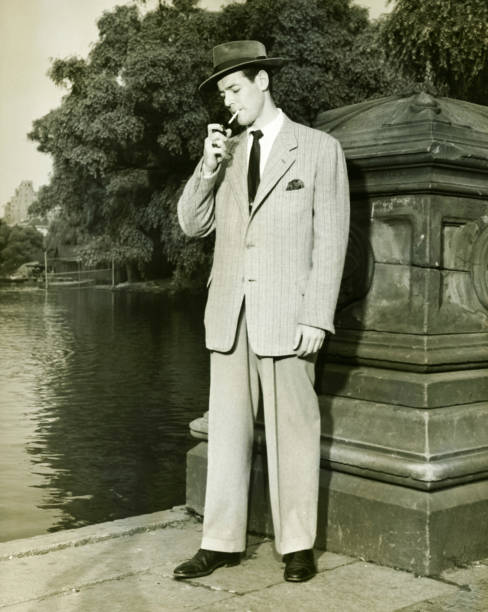 man 照明シガレットで湖の公園（b &w - men fedora hat 1940s style ストックフォトと画像