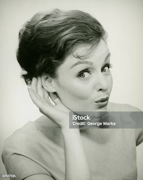 Giovane Donna Coppettazione Mano Allorecchio Verticale - Fotografie stock e altre immagini di Bianco e nero