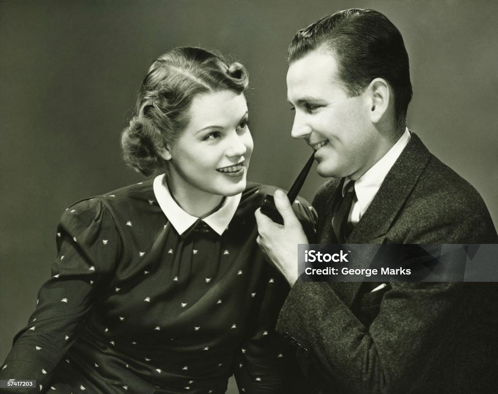 Retrato de pareja joven, hombre que agarra tubería, sonriendo, (vertical - Foto de stock de Anticuado libre de derechos