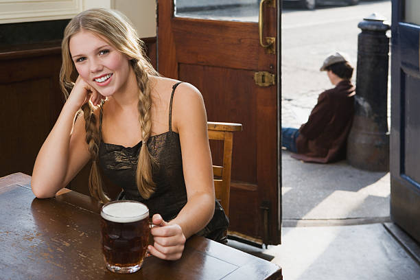 mujer joven bebiendo en el bar - barred windows fotografías e imágenes de stock