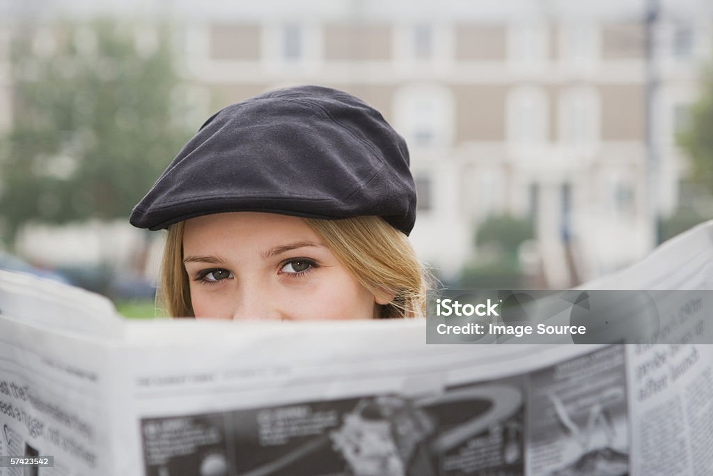 Close up of young woman reading newspaper - Foto de stock de Jornal royalty-free