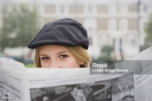 Foto de Close Up Of Young Woman Reading Newspaper e mais fotos de stock de Jornal - Jornal, Inverno, Mulheres