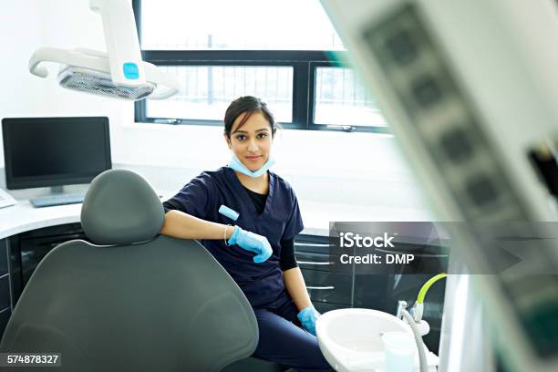 Dental Assistant Sitting On A Dentist Stool Stock Photo - Download Image Now - Dentist, Indian Ethnicity, Asian and Indian Ethnicities