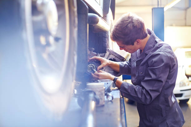 istock Mechanic examining part in auto repair shop 575131925