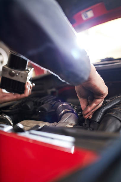 istock Close up mechanic arm reaching in car engine 575132017