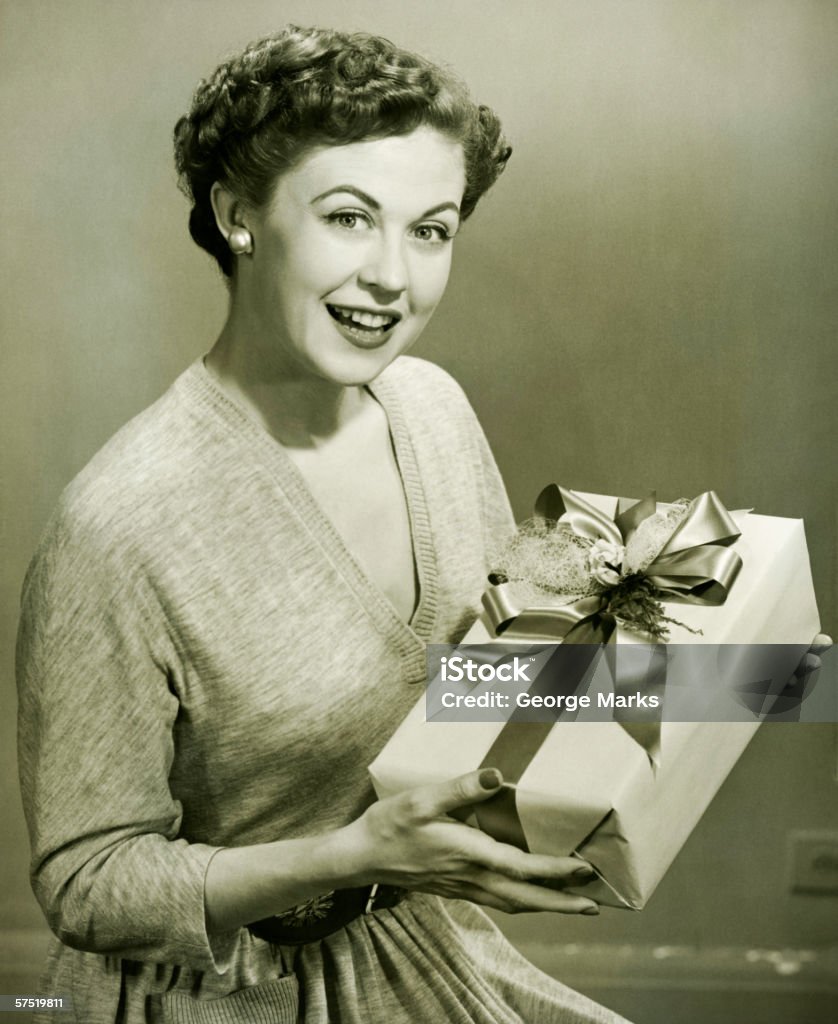 Mujer agarrando envueltos regalo en una suite tipo estudio, (B & W, Retrato - Foto de stock de Anticuado libre de derechos