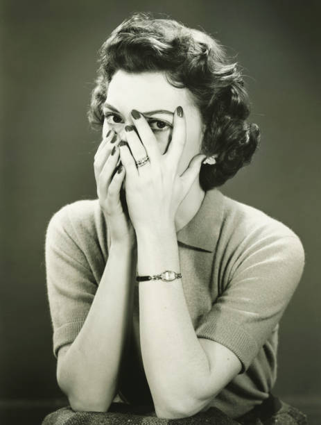 Woman covering face, peeping through fingers, (B&W)  vintage women stock pictures, royalty-free photos & images